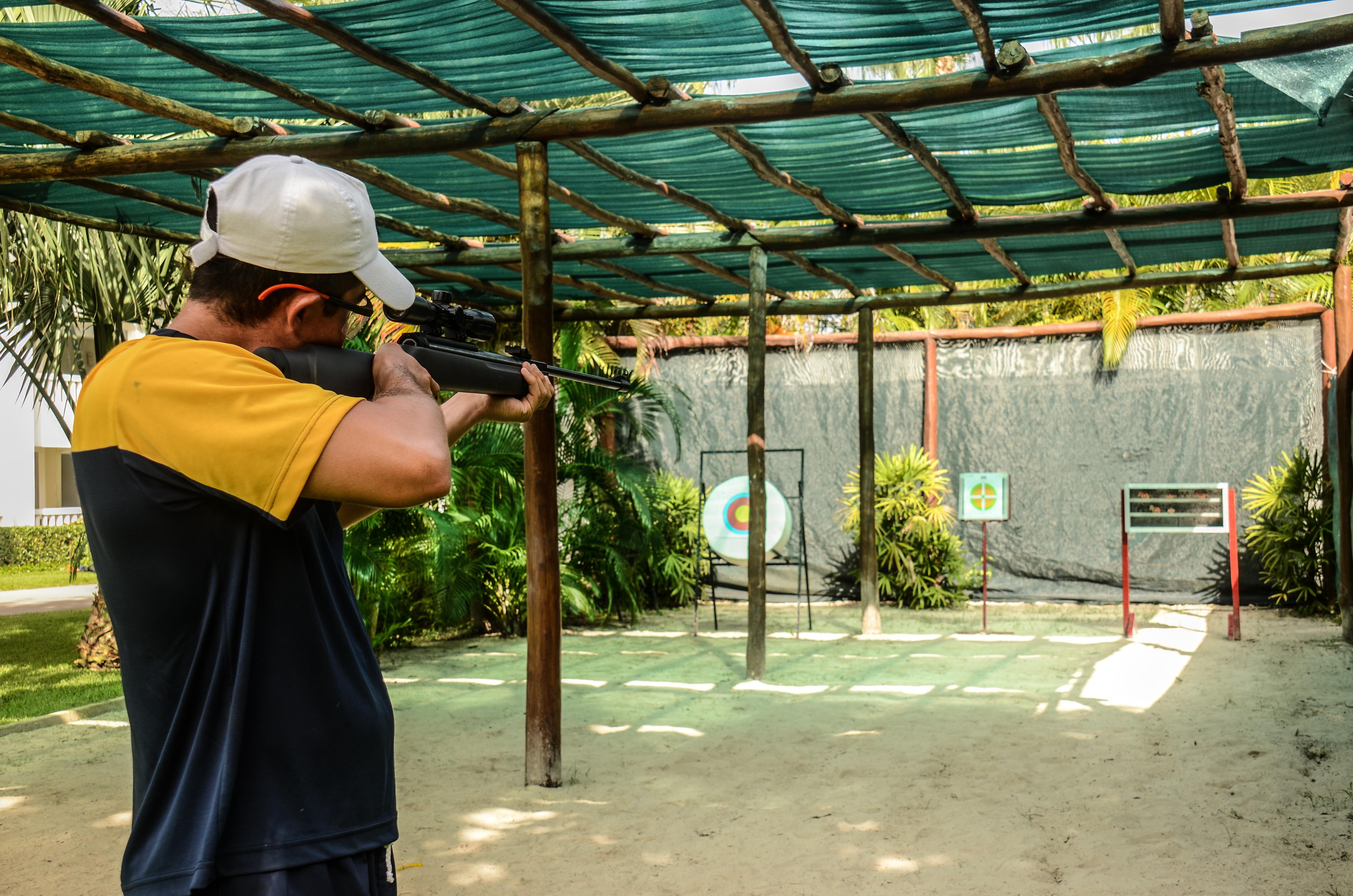 Grand Sunset Princess Playa del Carmen Exteriér fotografie A man shooting a rifle at a target